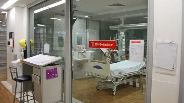 A medical isolation unit in a hospital with glass walls.