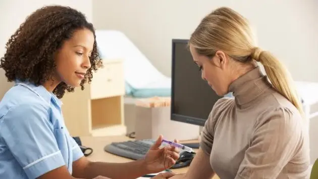 A nurse administers a vaccine to young woman.